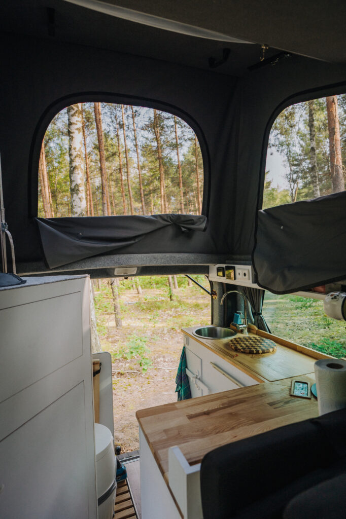 Kamper-17 wnętrze kampera wynajem woodcloud kuchnia i widok na las